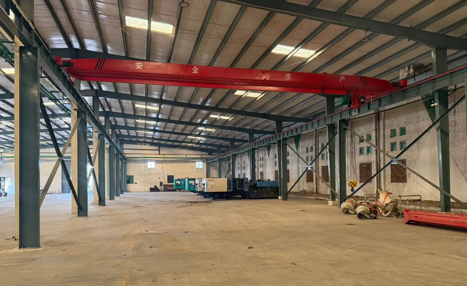 Overhead crane runway and steel portal frames inside the Haier JW Vendor City production hall in Lahore
